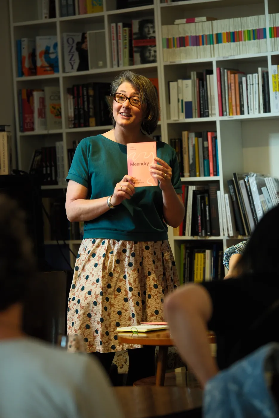 Lenka Kapsová ukazuje knihu Meandry publiku