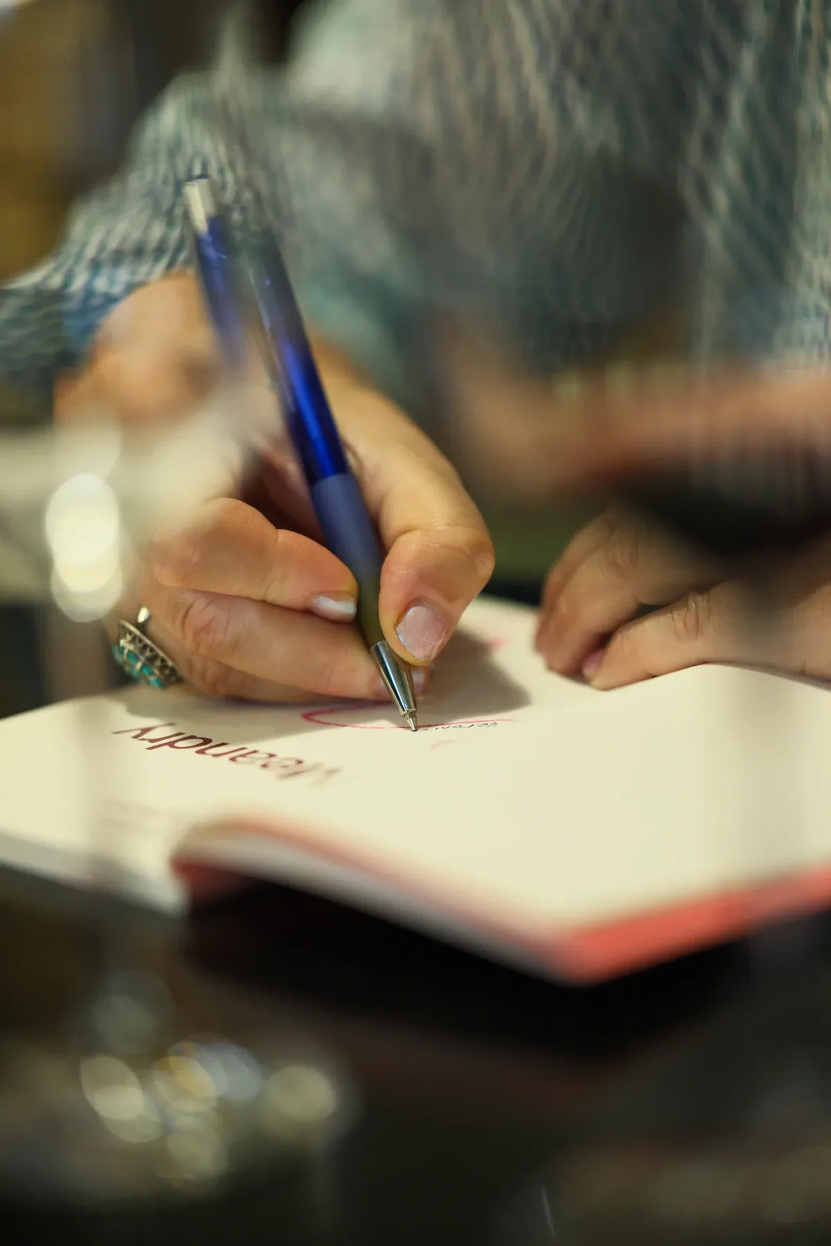 Detail ruky podepisující knihu Meandry